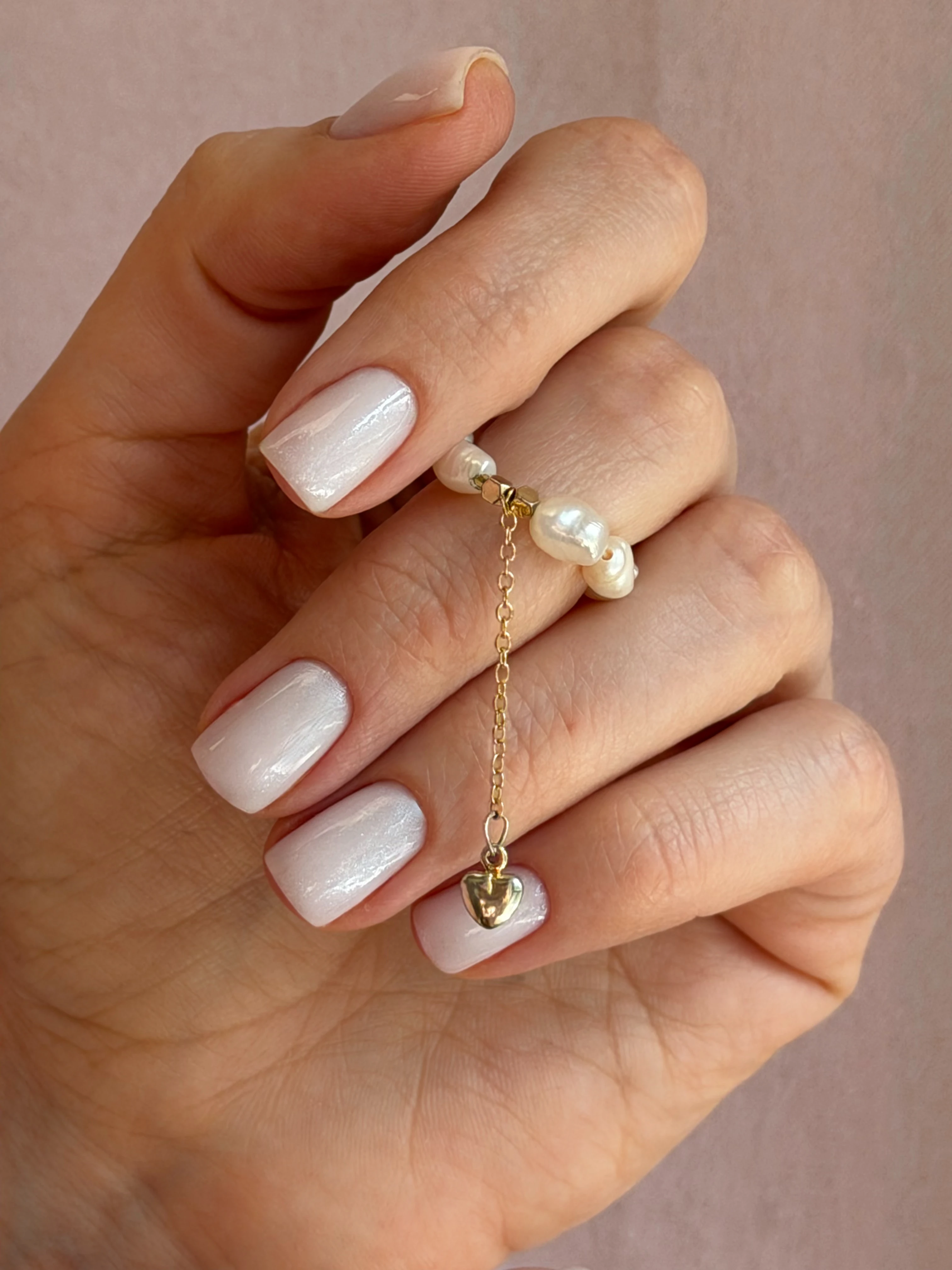 Pearlescent milky white gel polish on squoval nails with a pearl heart ring, done at My Beauty Space nail salon in Mississauga.