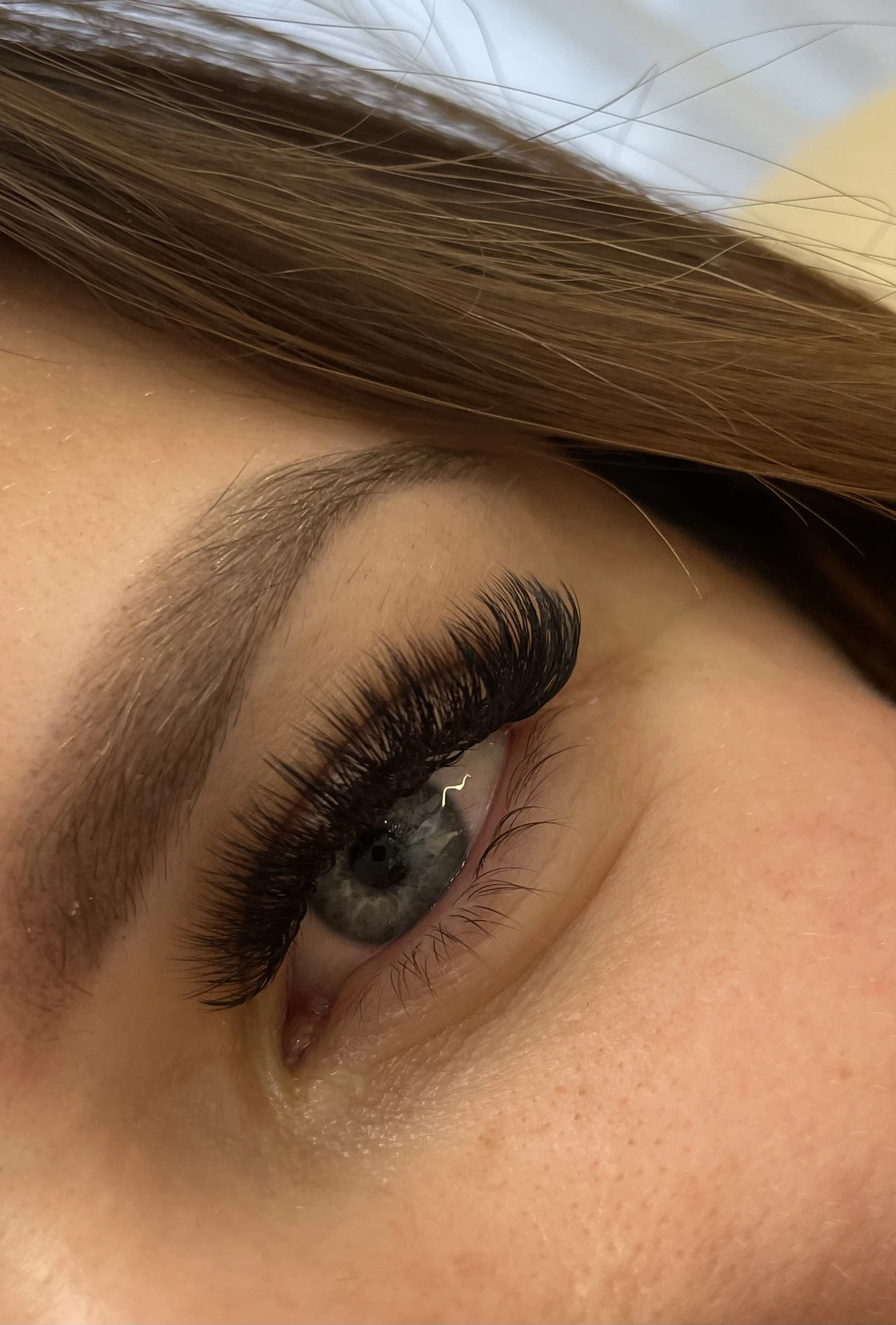 Blue-eyed client with dense 4D volume lash extensions and a softly groomed light brow at My Beauty Space.