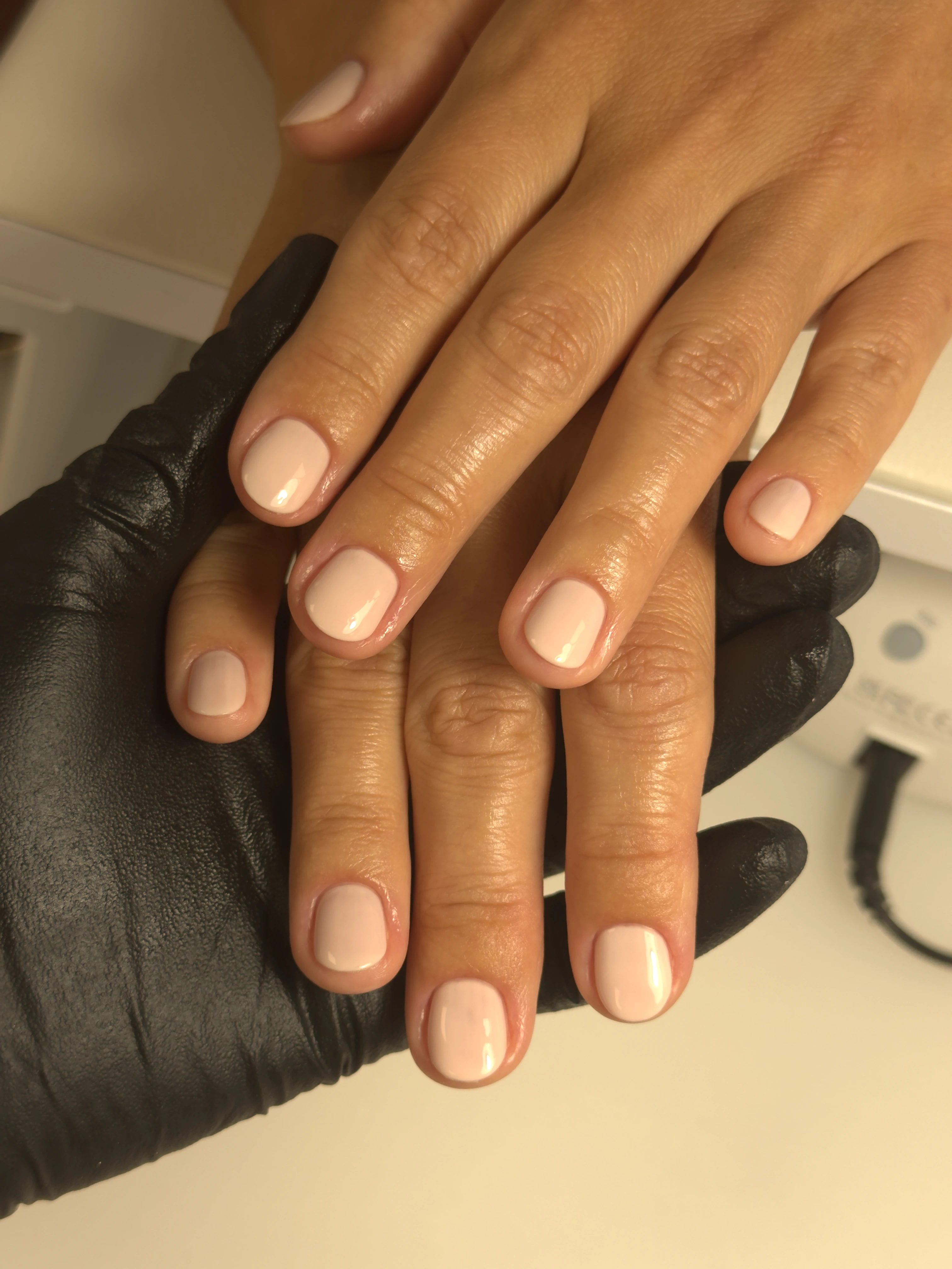 Light beige regular polish on short rounded nails beside a UV lamp, finished at My Beauty Space manicure bar in Mississauga.